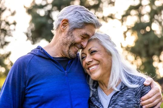 Older Couple on a Walk Outside Closeup of Them Hugging